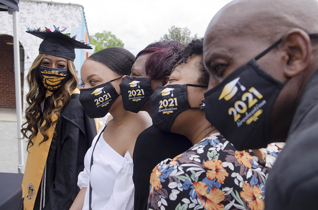 A B-S-W graduate and family, wearing 2021 graduation masks