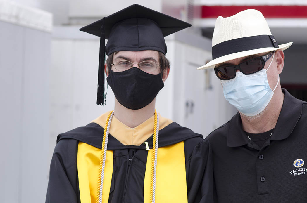 A 2021 B-S-W graduate with guest, both wearing masks