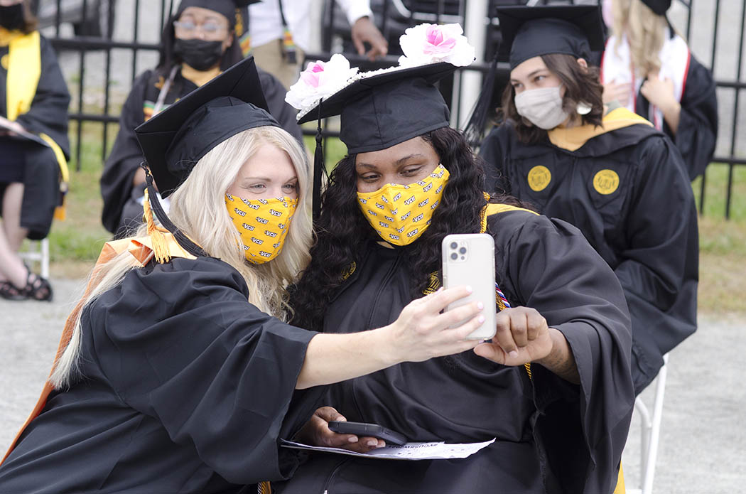 Two B-S-W graduates, both masked, pose for a selfie photo.