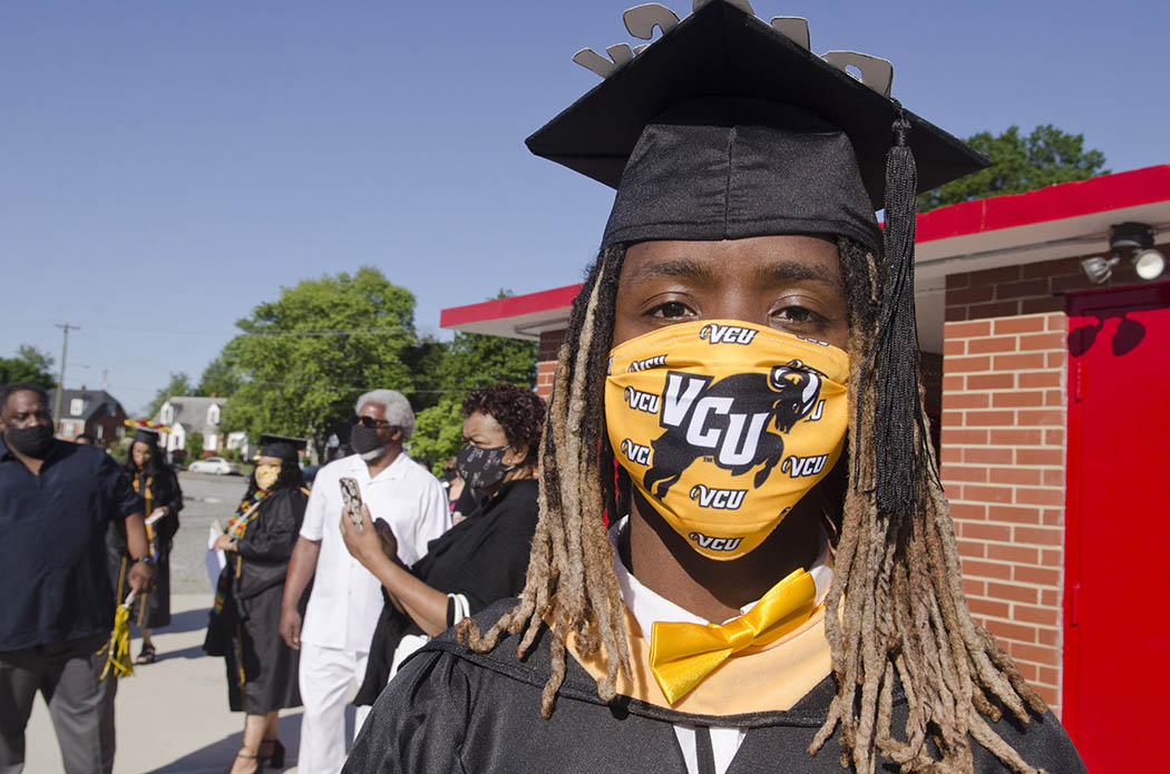 An M-S-W graduate wearing a gold bowtie and gold V-C-U mask with the Rams logo