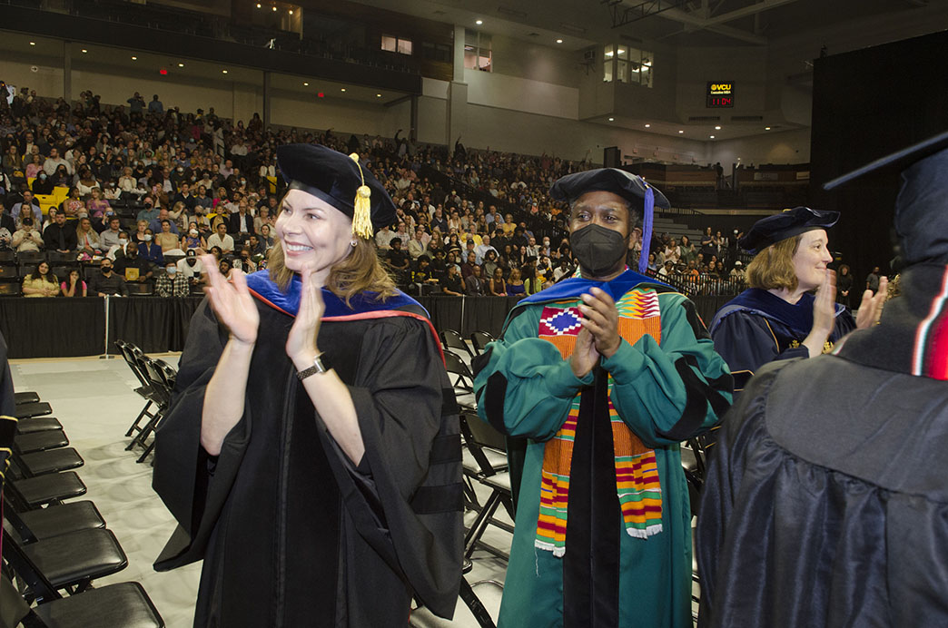 VCU interim dean Rebecca Gomez and associate professor Maurice Gattis applaud during the May 2022 Commencement ceremony.
