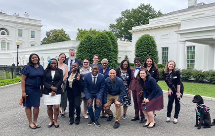 Alumni Allison Gilbreath and Sophia Booker, far left, pose with a group during a June 2022 visit to the White House