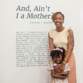 Nicole Corley stands with her daughter, Zuri, in front of a display for her art exhibit, And Aint I a Mother?