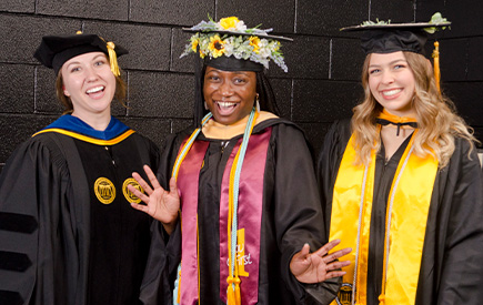 Ph.D. graduate and speaker Leah Bouchard, M.S.W. graduate/speaker Sophia Booker and B.S.W. graduate/speaker Paige Wise pose before the May 2022 Commencement ceremony.