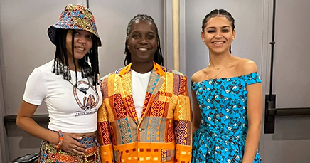 Social work associate professor Maurice Gattis is flanked by models Elijah Brown and Keely Buchanan at DC Fashion Week. All three are wearing custom clothing from Gattis' fashion line.