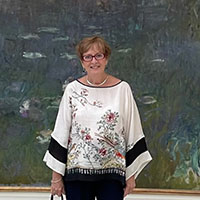 Marjorie Stuckle at Musée de l’Orangerie in Paris, standing in front of the painting Water Lillies by Monet