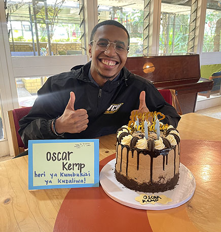 B.S.W. graduate Oscar Kemp celebrates with a birthday cake in Tanzania. The Tanzanian 