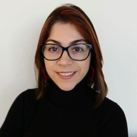 Headshot of Paola Roldan wearing a dark top