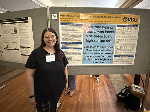 A student standing in front of a research poster